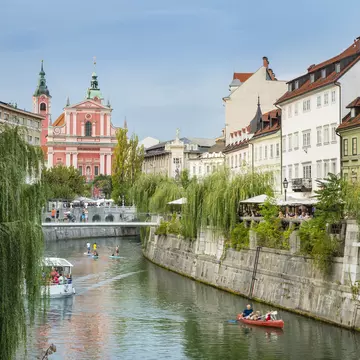 KayakBoats and paddle boarders travel down the tree-lined Ljubljanica River, which flows through the centre of Ljubljana.