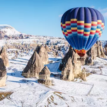 Colorful hot air balloons flying over a mountain