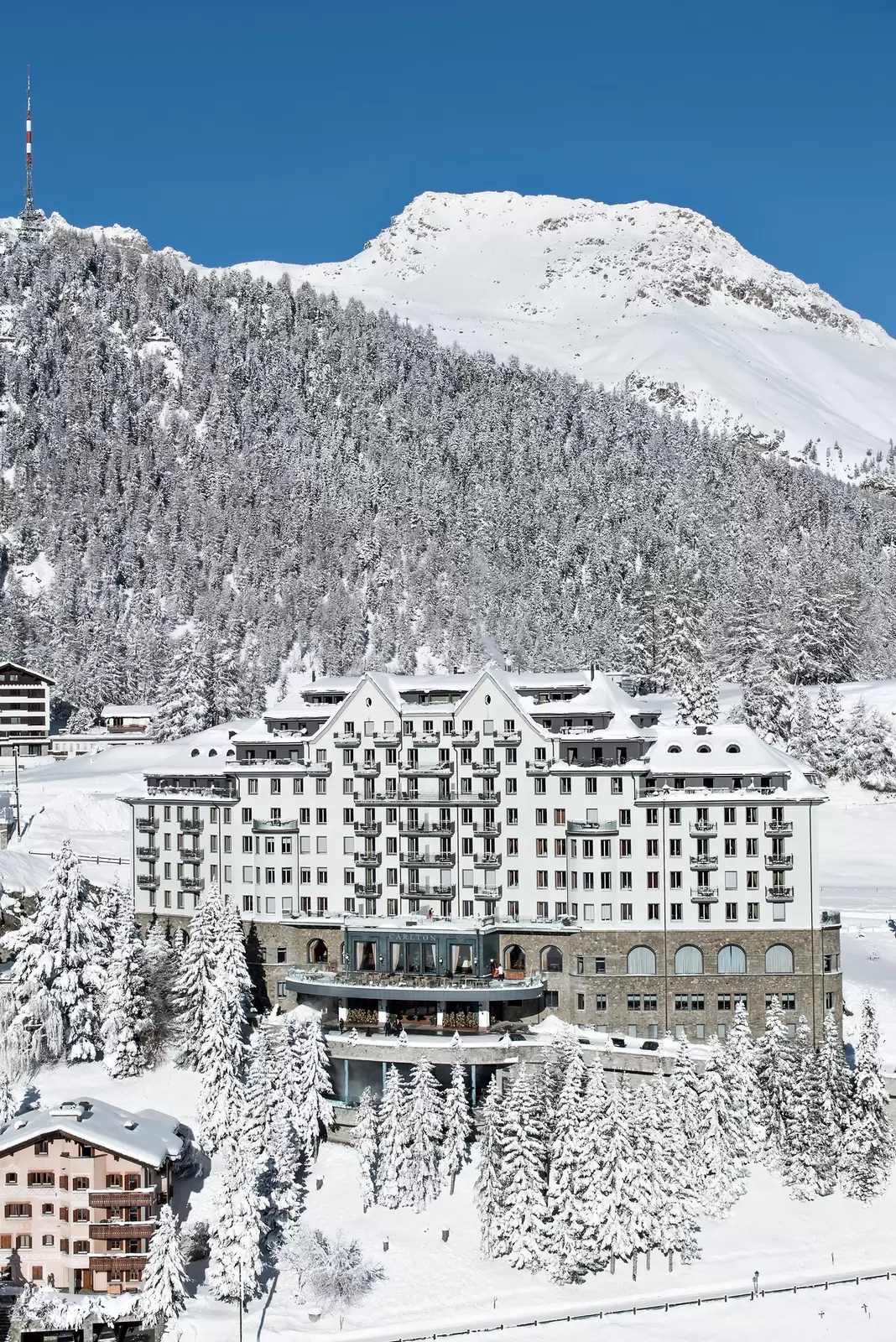 A multistory hotel in a snowy, mountainous landscape.