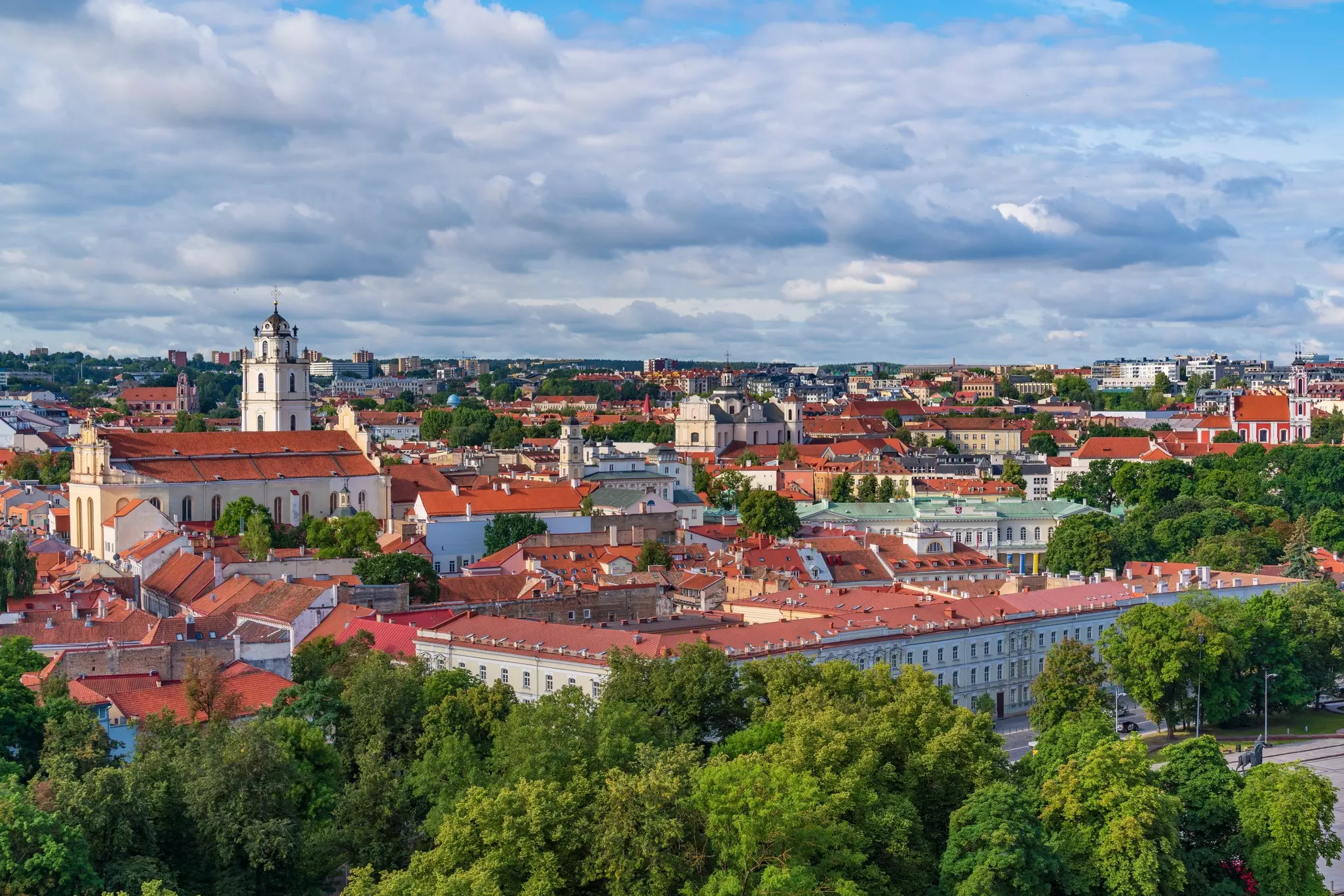 Panoramic view of a town with red-roof historic buildings on a sunny day.