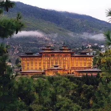A view over forests and the traditional-style Pemako Thimphu hotel in Thimphu, Bhutan. Pemako Thimphu