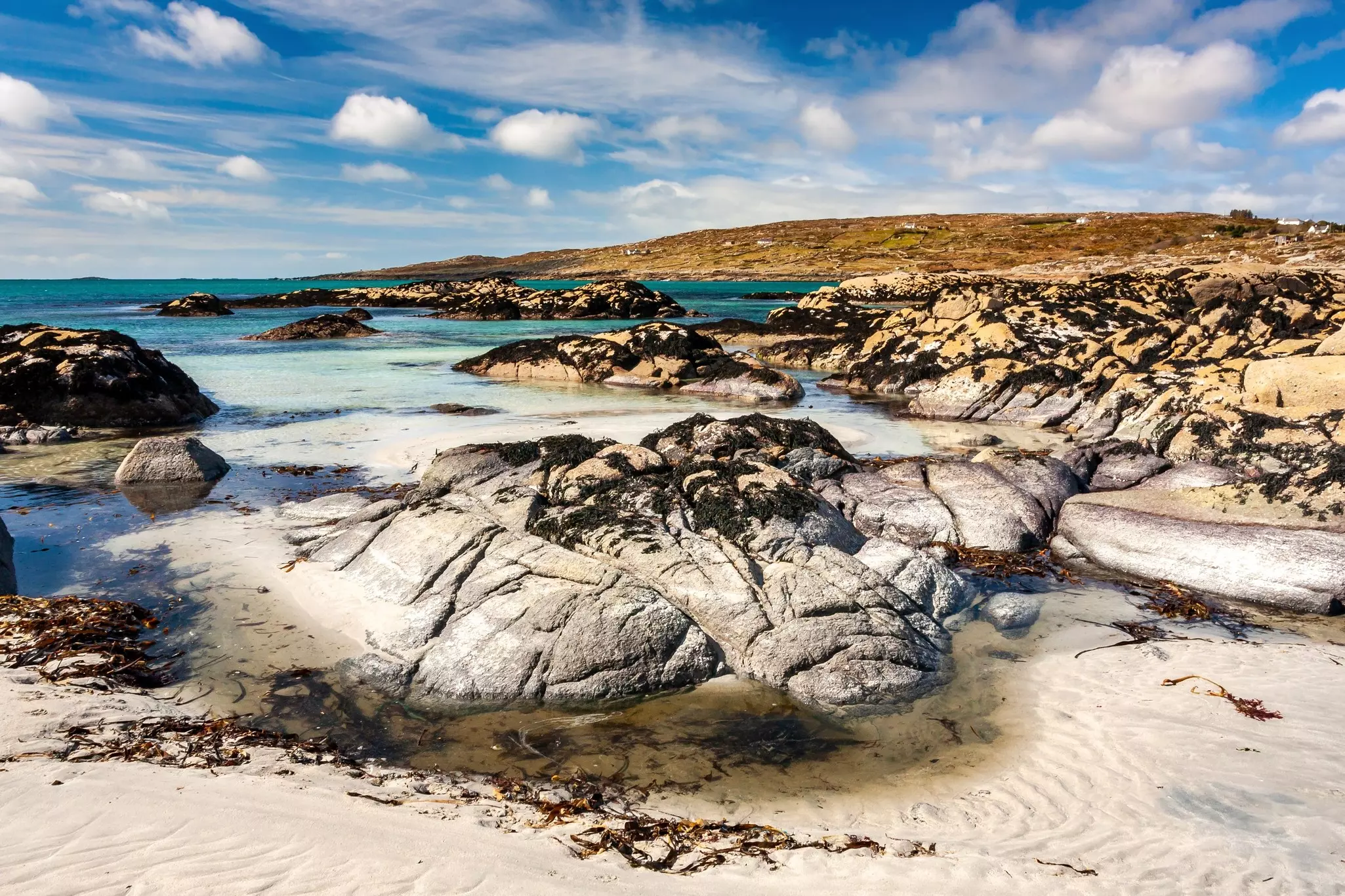 Sand and rocks on the beach at Dog's Bay in Roundstone, Ireland.