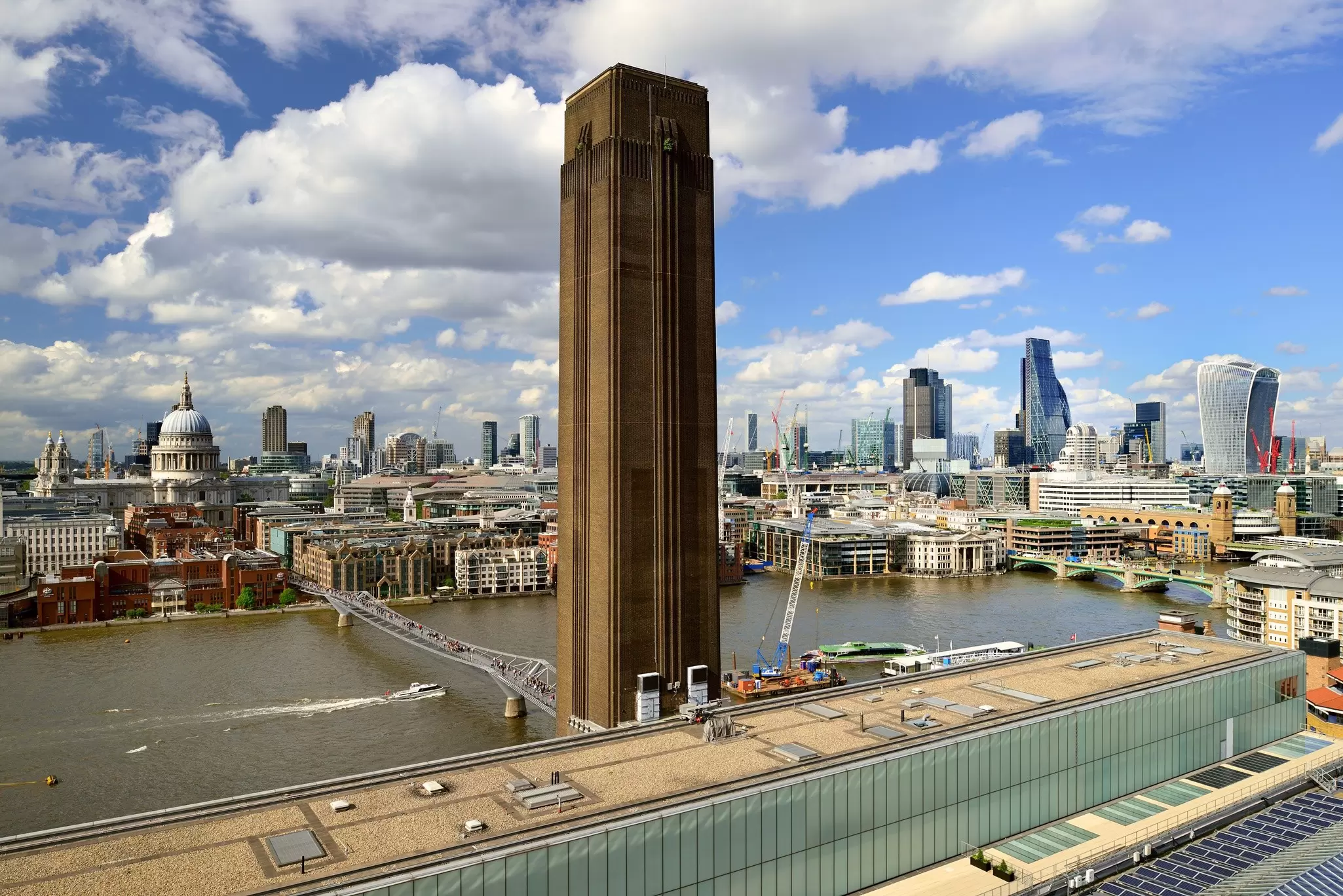 View from a viewing platform across London, with a large brick chimney in the foreground and the river beyond