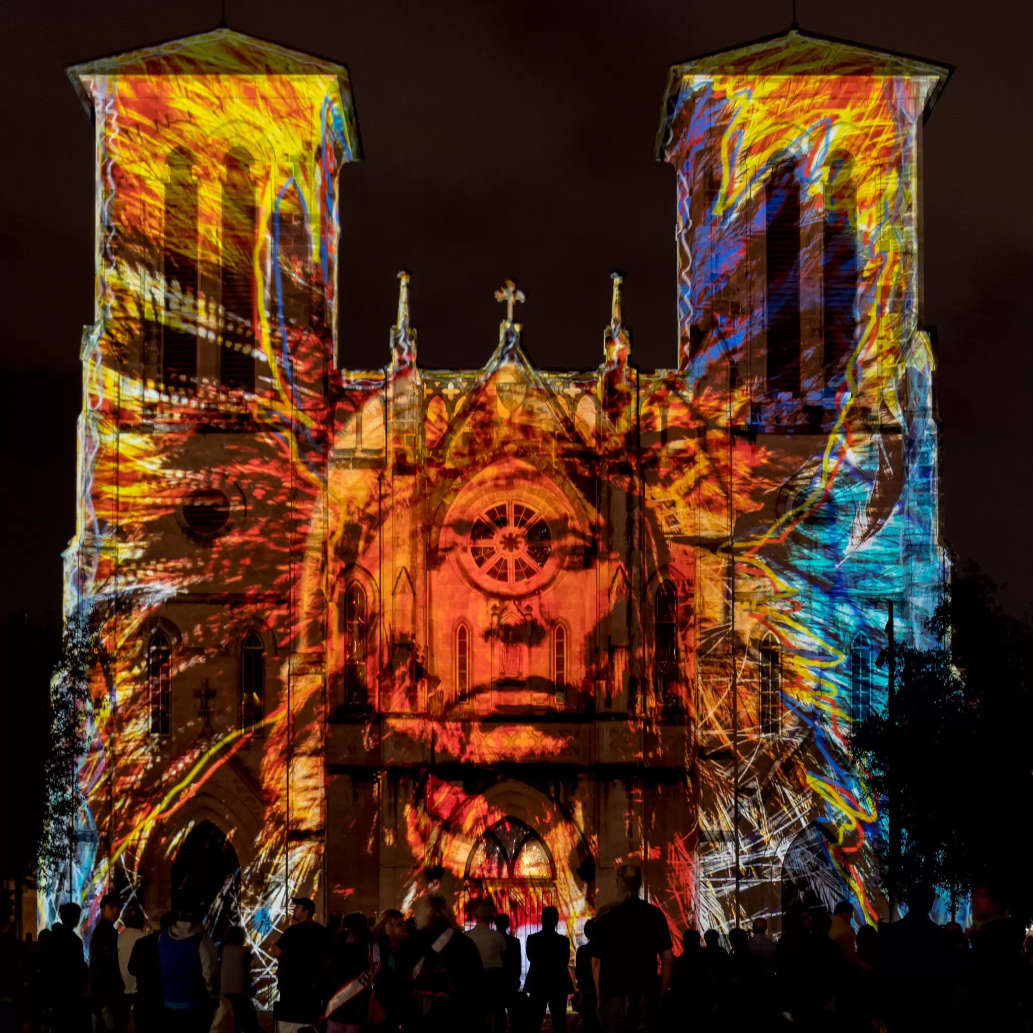 An image of a Native American projected onto the facade of a cathedral