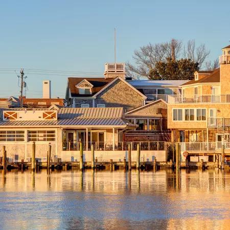 Shingled buildings sitting beside a bay during golden hour