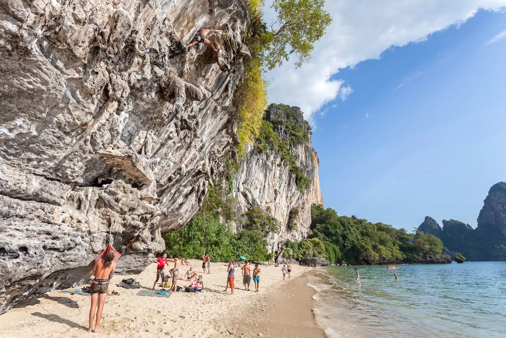 View of rock climbers and tourists on Railay beach in Krabi Province, Thailand.
