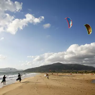 Kite surfers on Playa de los Lances on a sunny day along the Costa de la Luz in Spain.
