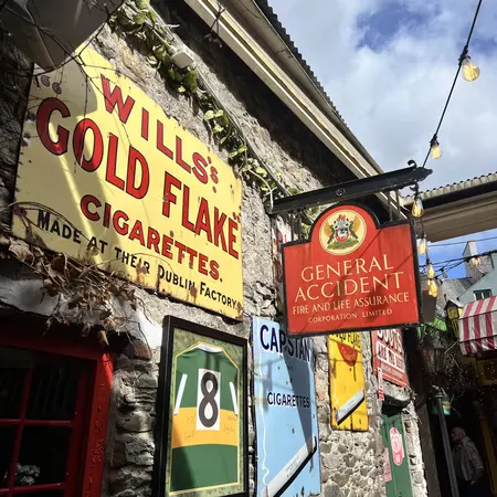 A wall covered in vintage signs and adverts.