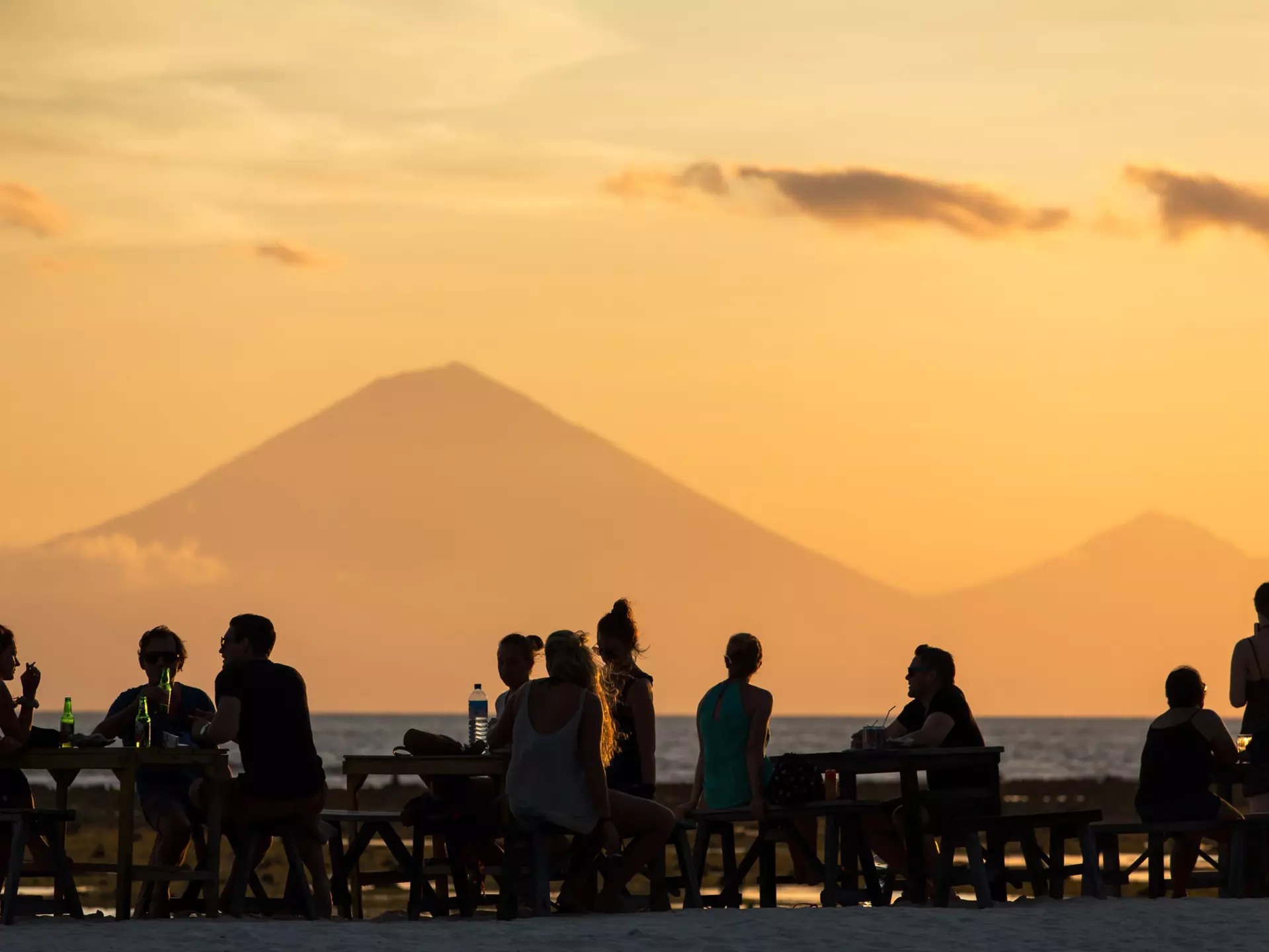 People on Gili Trawangan watching a sunset with a view of the Gunung Agung volcano