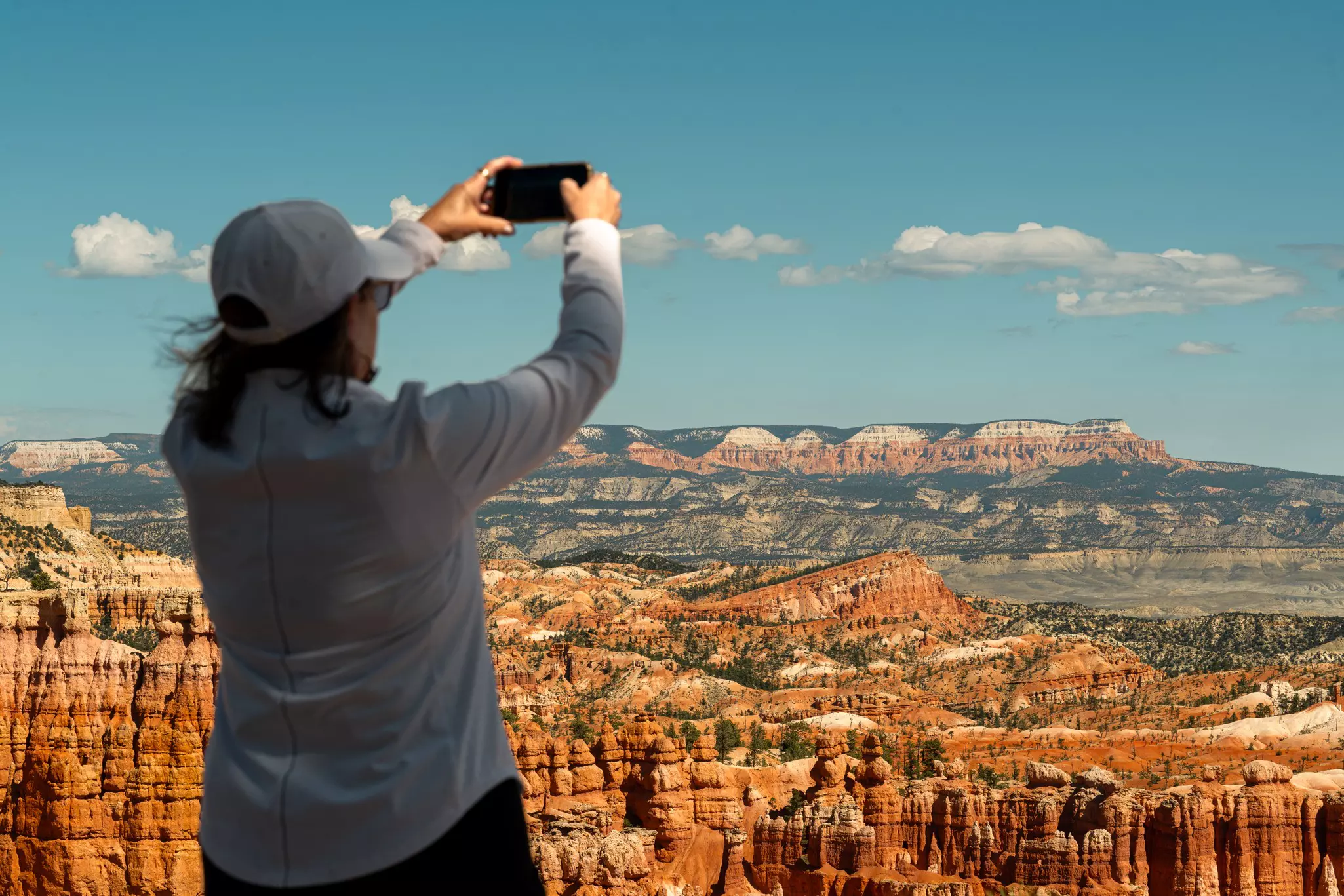 A woman takes a photo on her cellphone at Bryce Canyon National Park.
