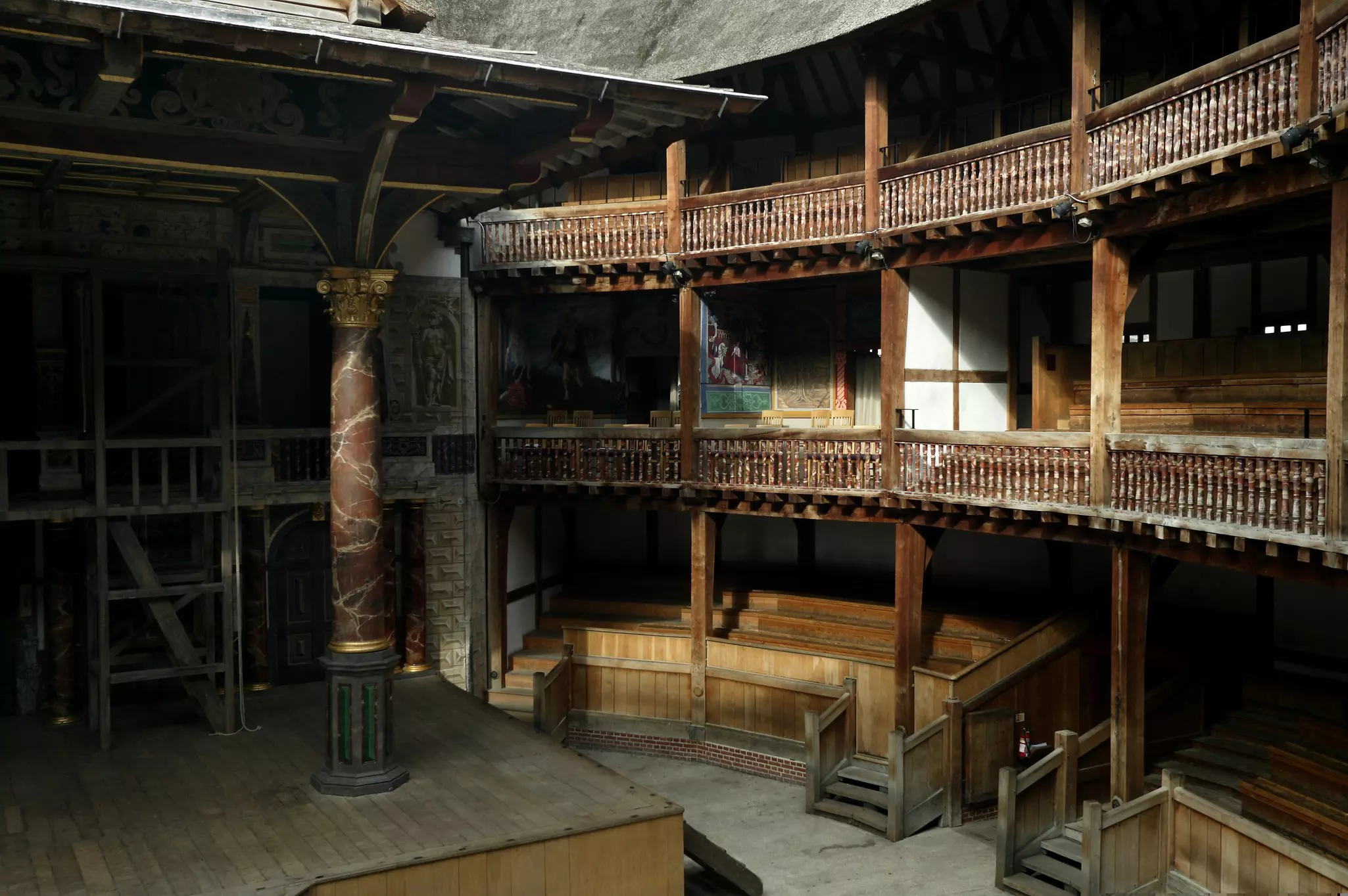 Wooden balconies around an open space in front of a stage.