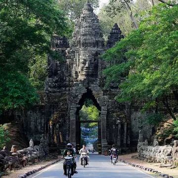People ride through the North Gate of Angkor Thom, part of Angkor Wat complex.