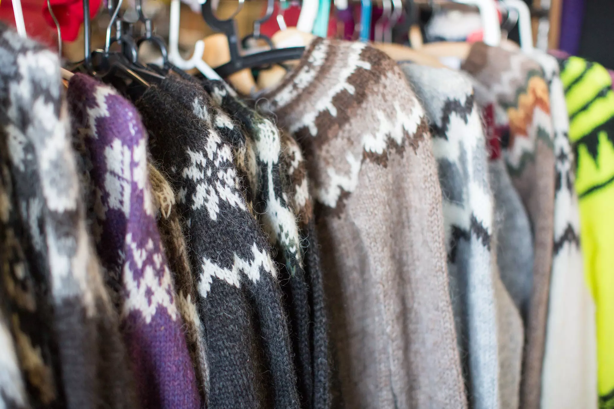 A rack of traditional Icelandic wool sweaters of different colors and patterns.