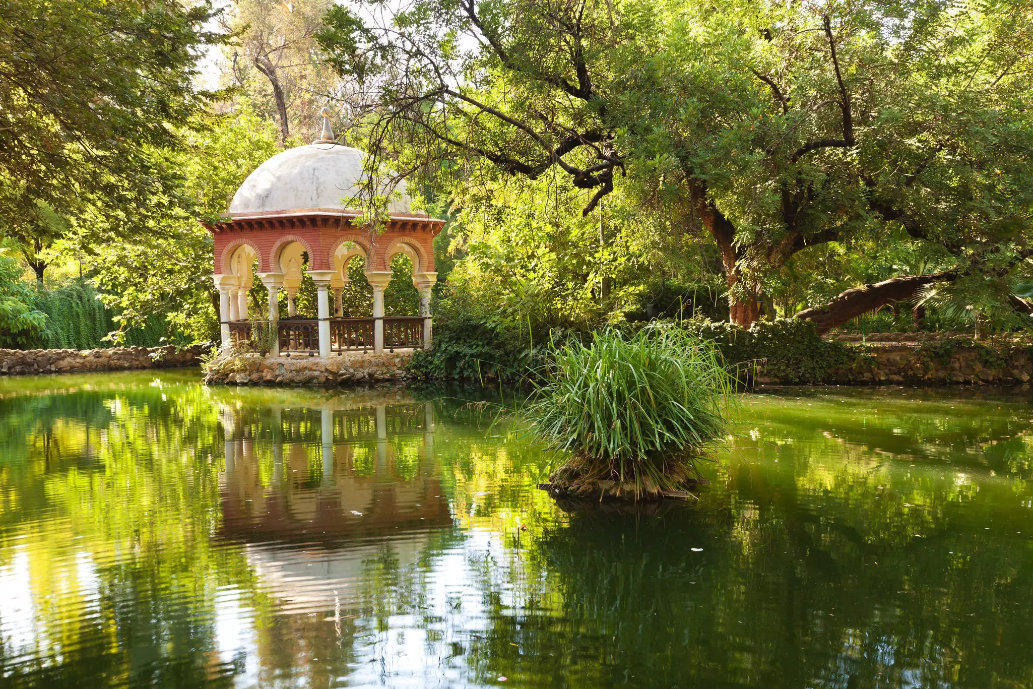 A pavilion reflected in a pond at Parque Maria Luisa