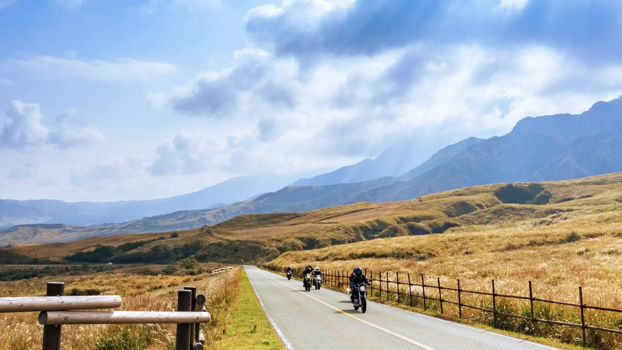A car running on Aso Milk Road while looking at the beautiful view of the refreshing autumn weather
