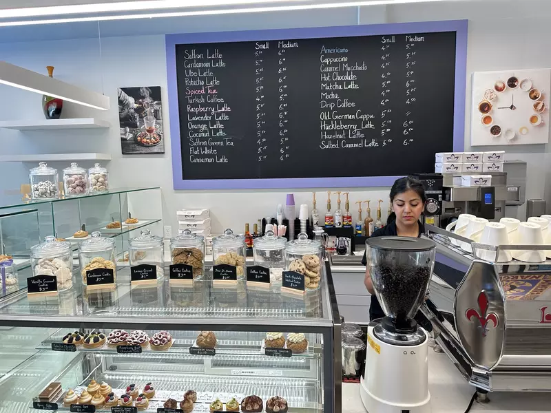 Owner Narges Sham at Sunshine Spice Cafe with jars of cookies, coffee cups and syrups all around