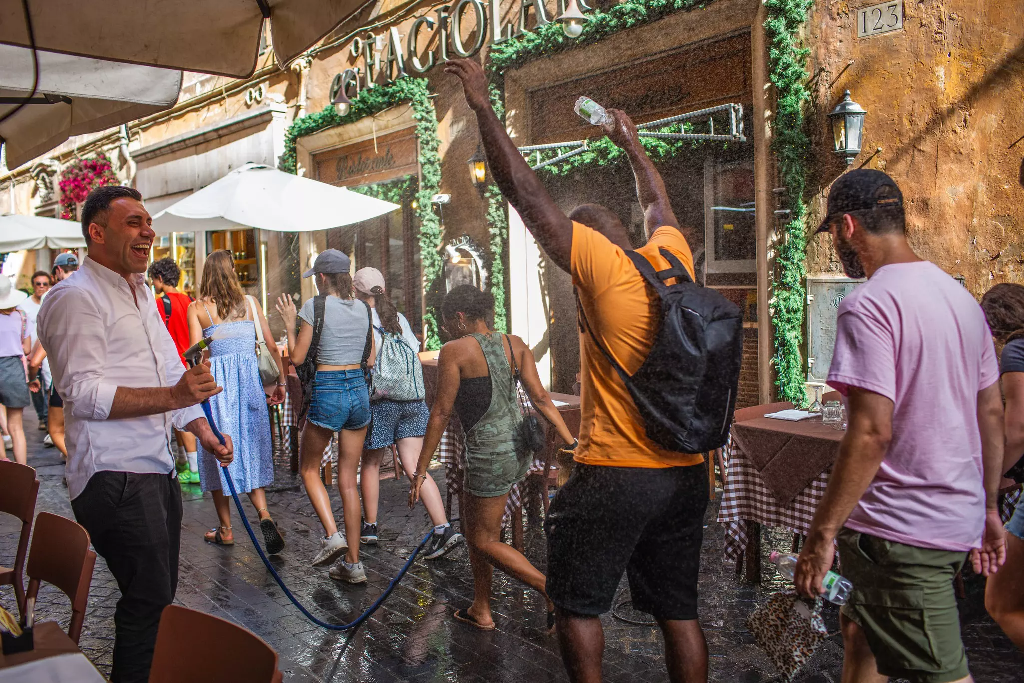 A restaurant employee sprays passersby with a water hose in Rome © Bloomberg / Getty Images