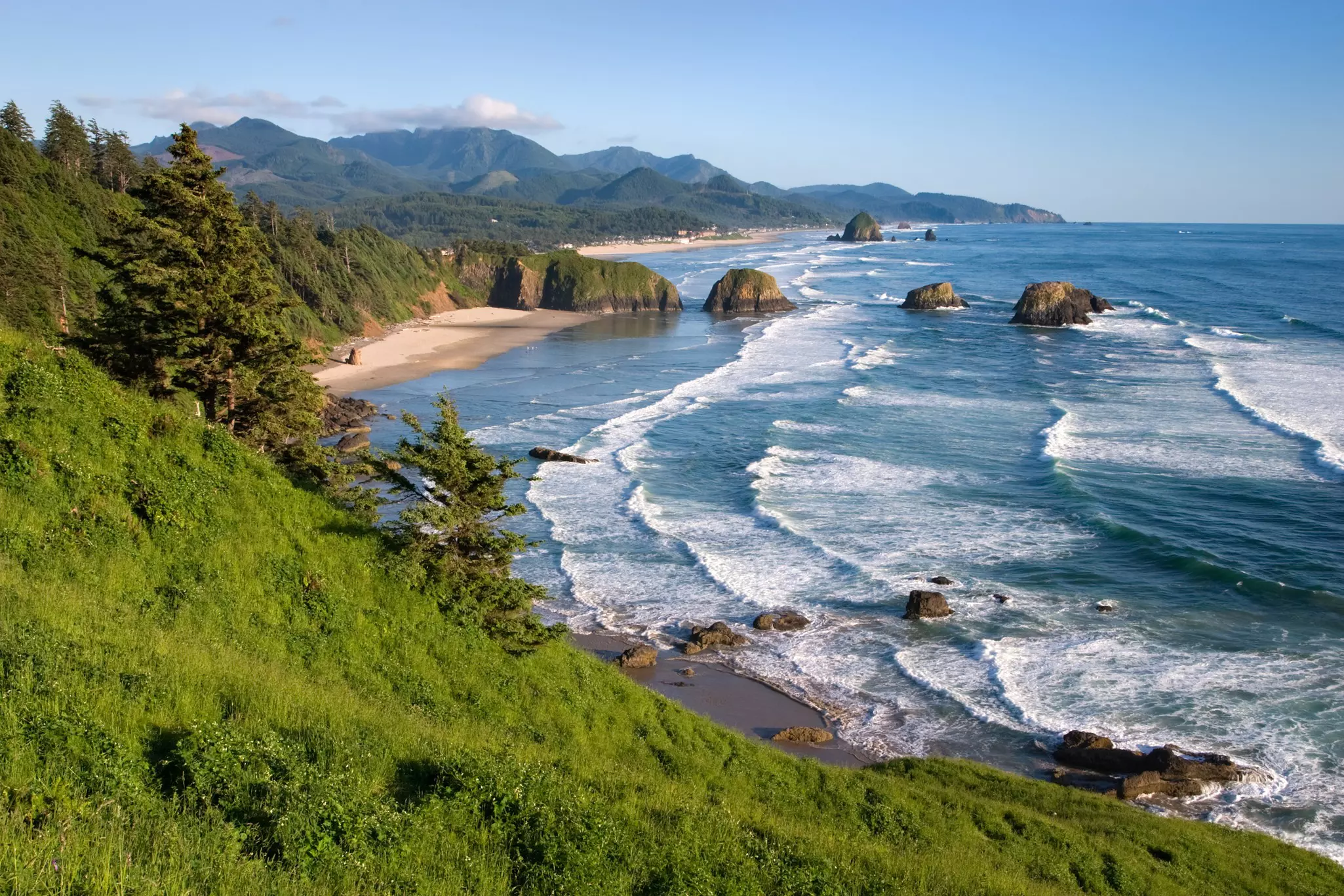 A beach with distinctive rocky stacks at the edge of the sand.