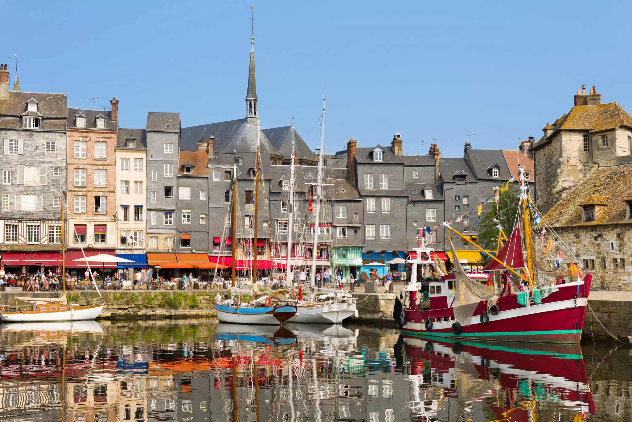 Yachts are part of the Honfleur harbor in a summer day
