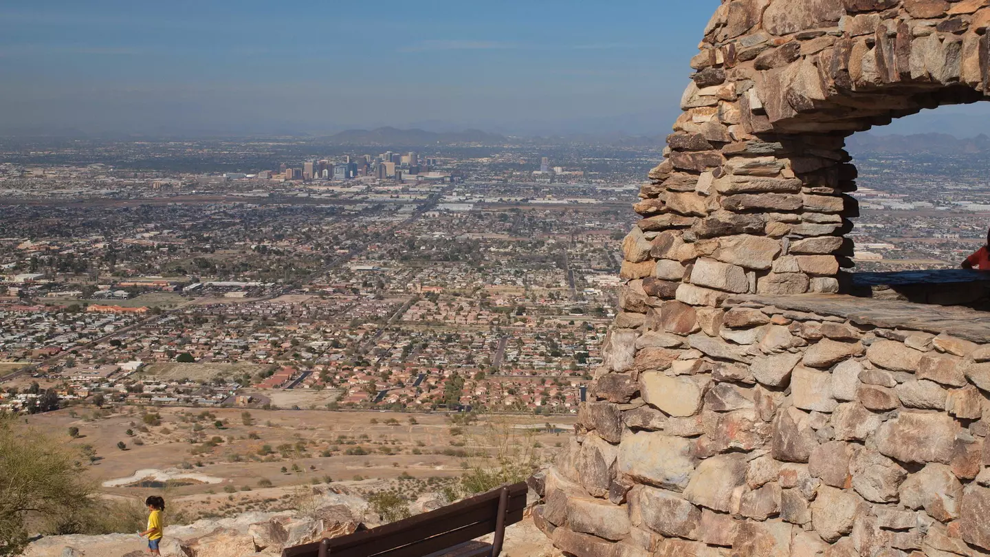 A bench at South Mountain Park offers a lookout onto the Phoenix skyline and desert in the distance