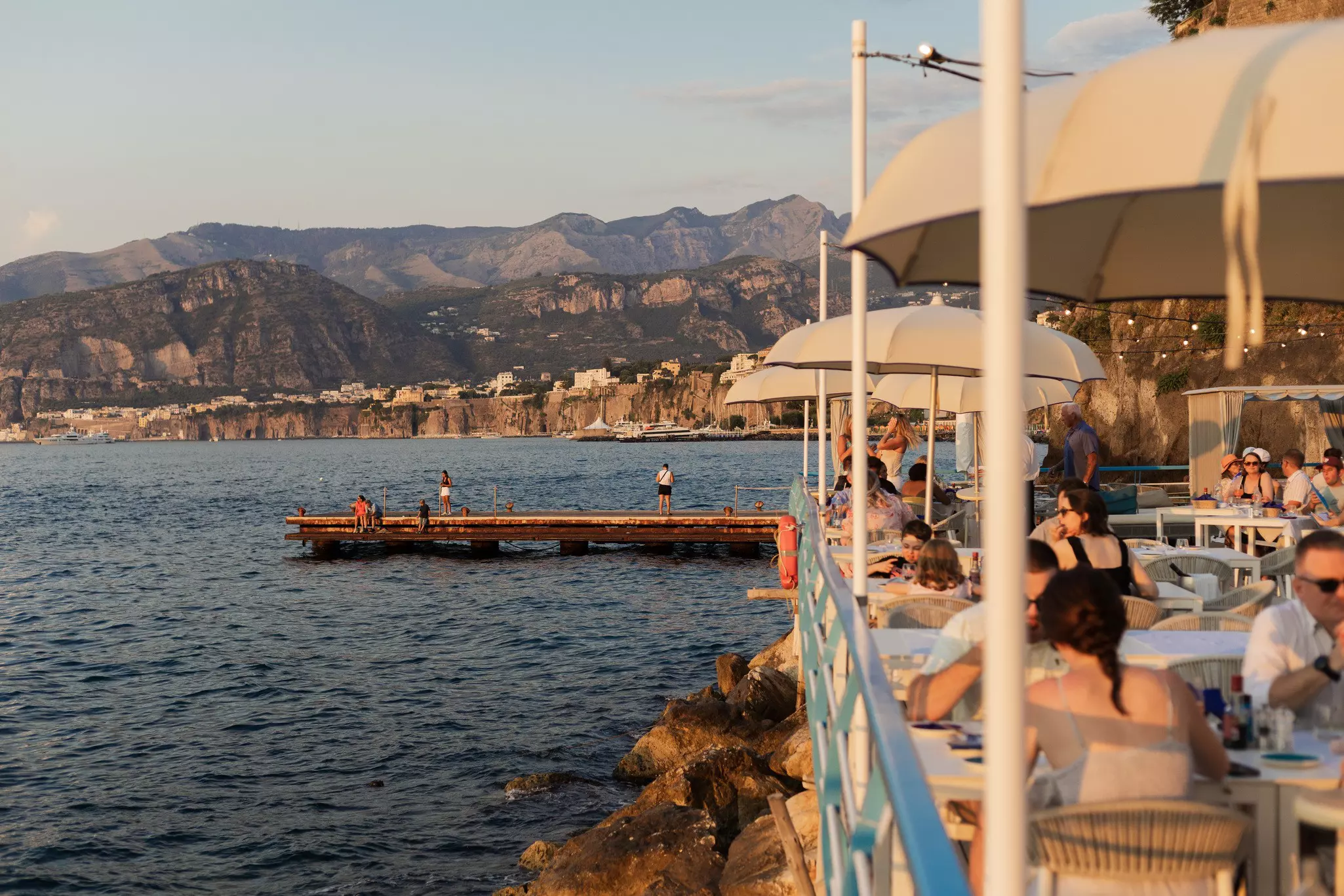 A view of the sea and people eating at Marina Grande, Sorrento, Italy. July 2025.
