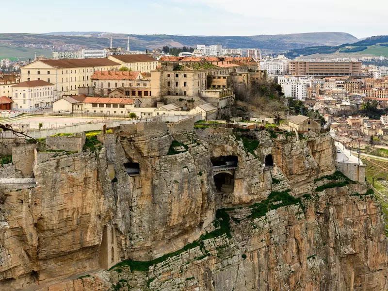 A town in Algeria built on top of a tall rock cliff. 