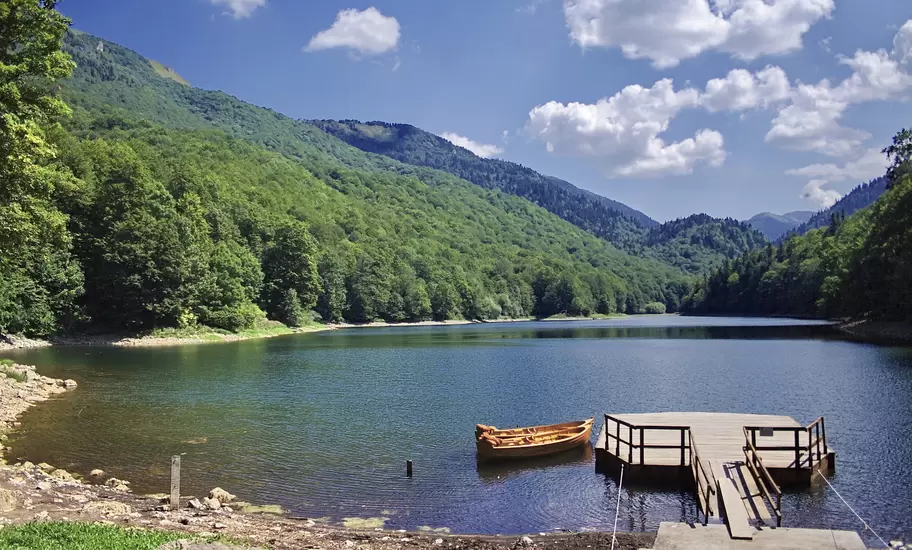 Biogradsko Lake in Biogradska Gora National Park: a wooden rowing boat beside a jetty below forested mountains