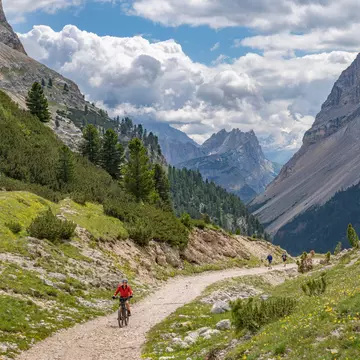 A woman riding her bike on a moutain path