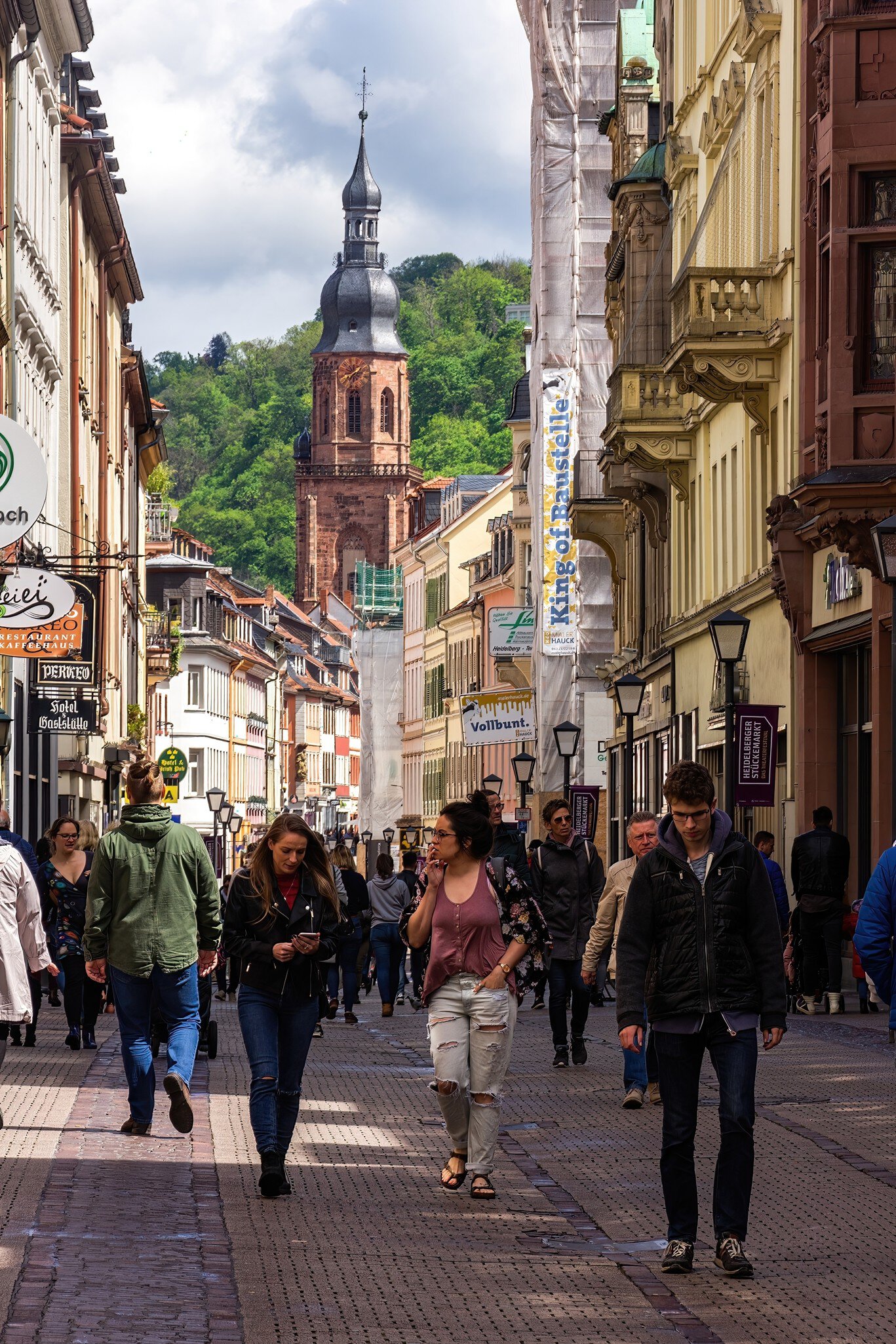 Gothic Heiliggeistkirche church towers over the cafe-lined Marktplatz in the Altstadt in Heidelberg, Germany.