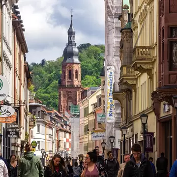 Gothic Heiliggeistkirche church towers over the cafe-lined Marktplatz in the Altstadt in Heidelberg, Germany.