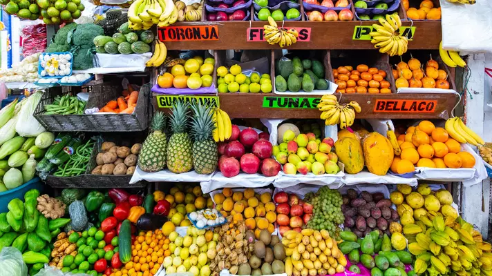 Pineapples, oranges, apples, bananas and other produce piled for sale in Lima, Peru.