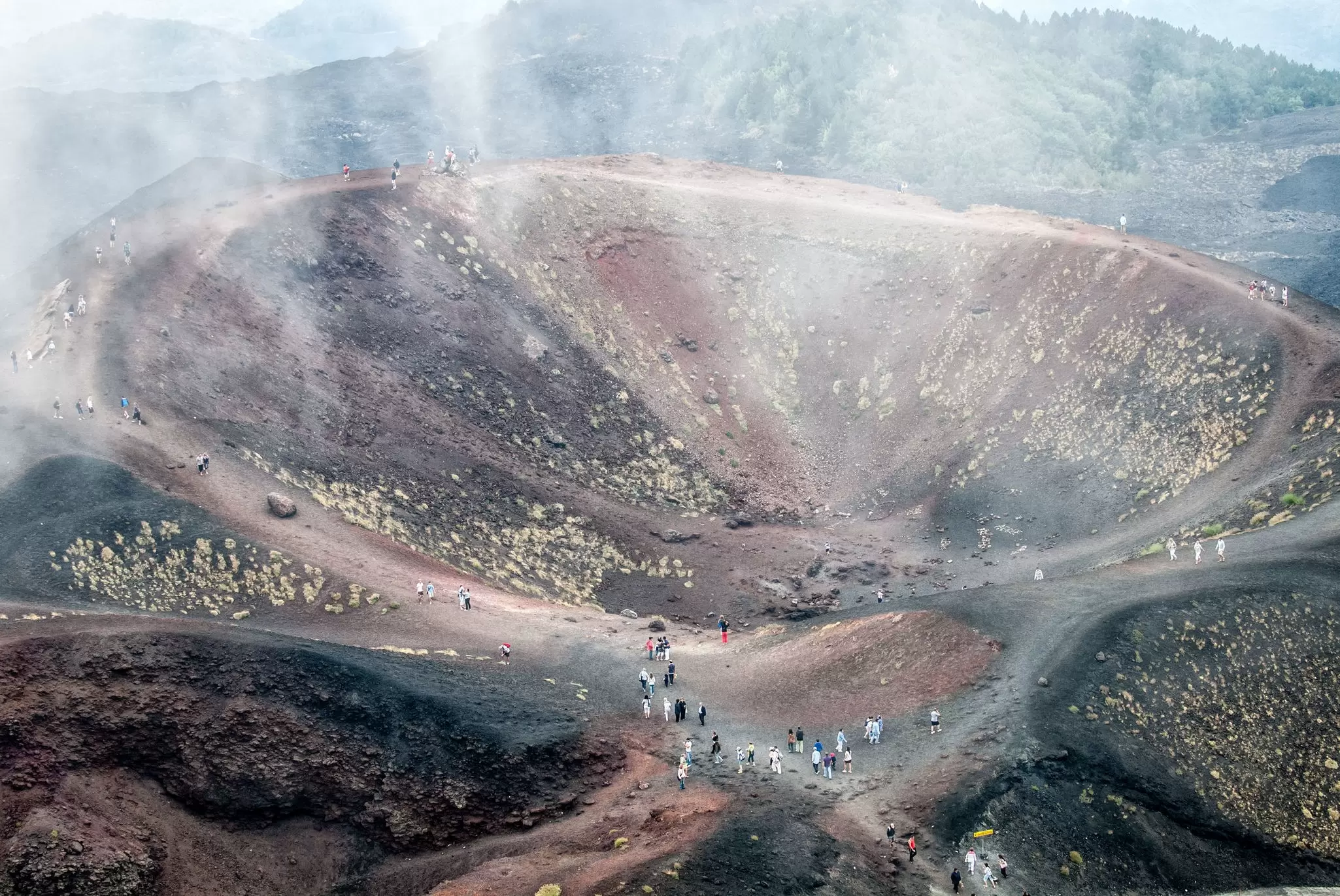 Aerial view of visitors approaching the crater of the Etna volcano.