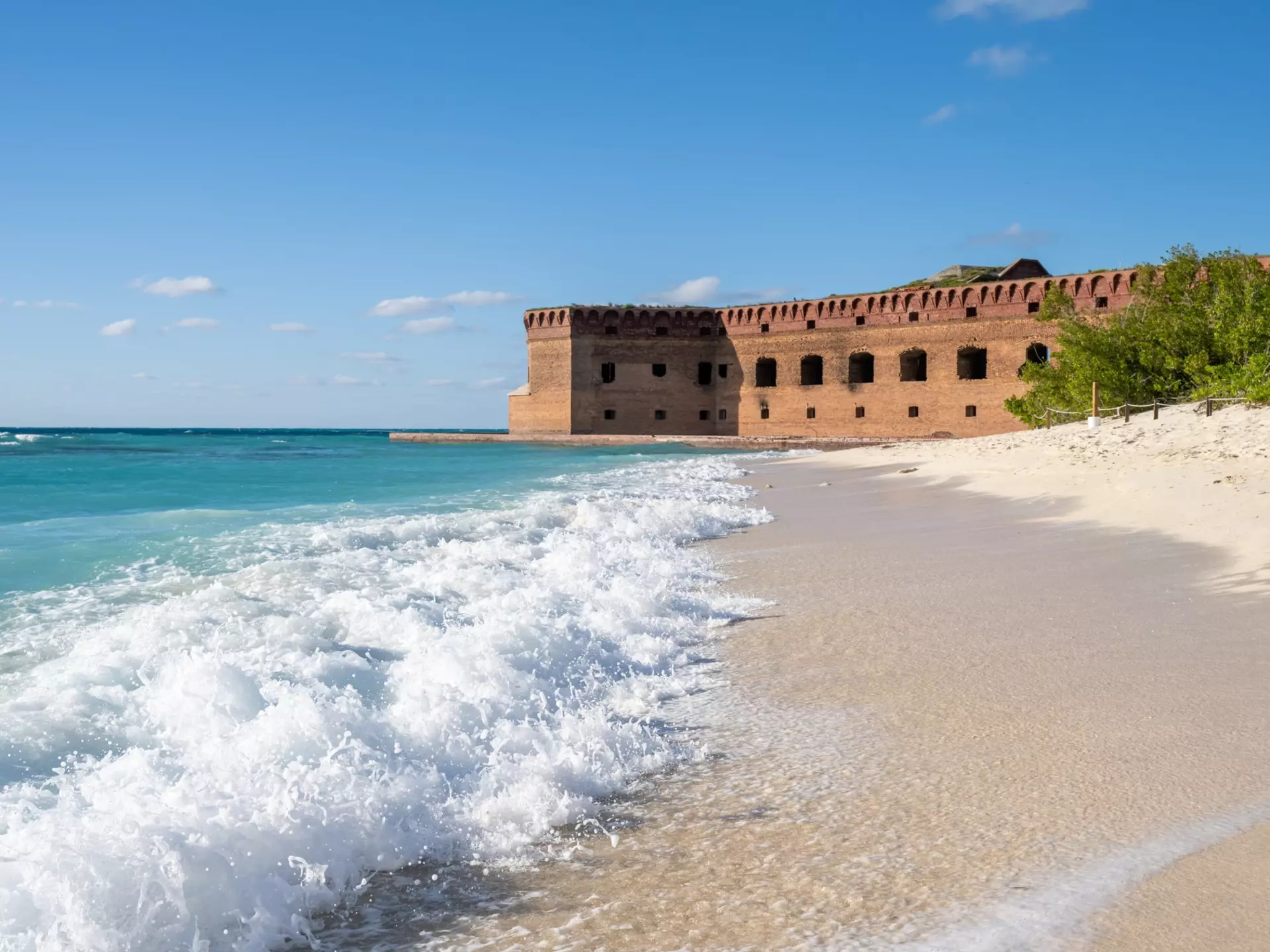 Waves crashing onto the empty beach next to Fort Jefferson. Lost_in_the_Midwest/Shutterstock