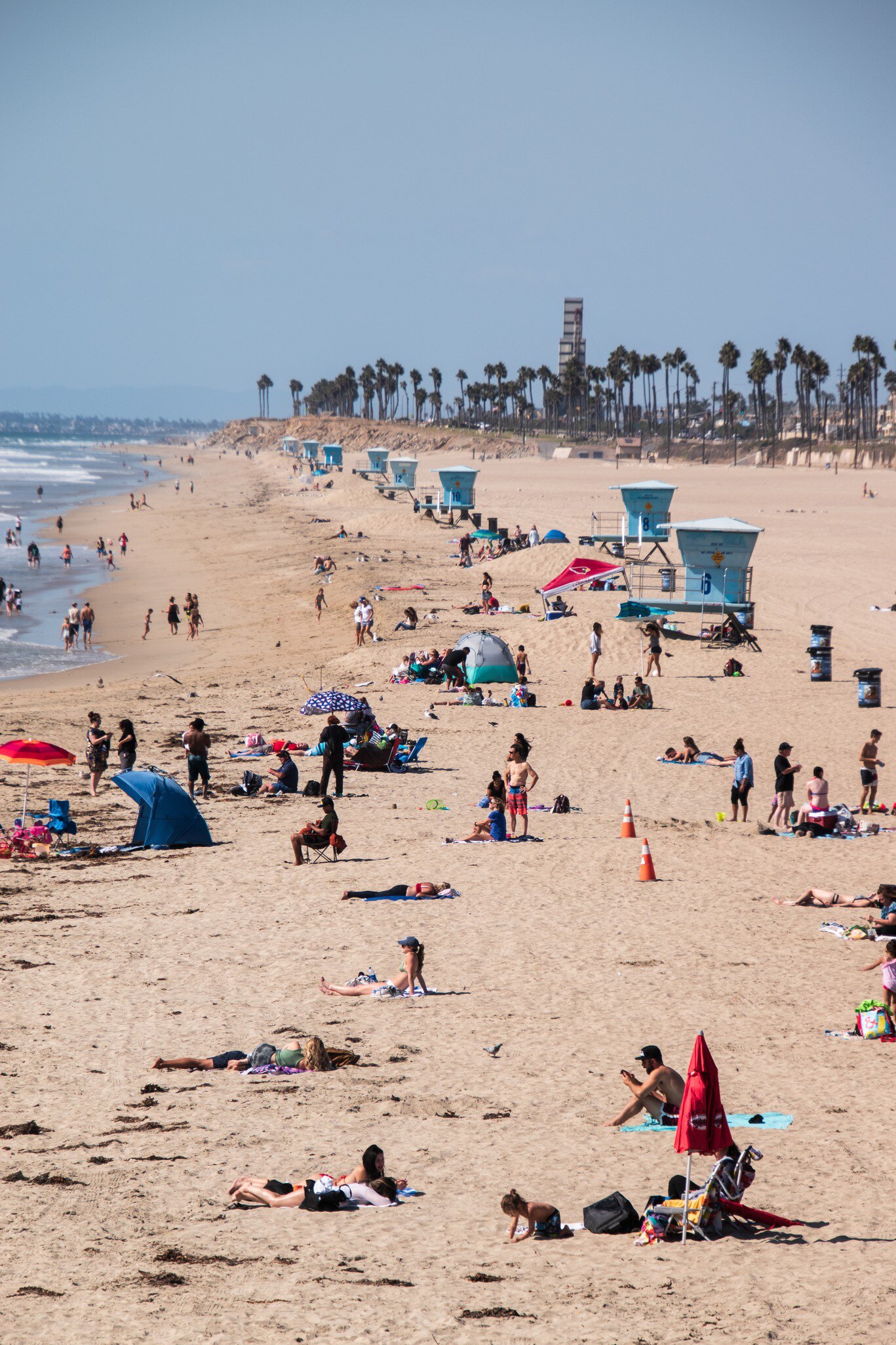 Huntington Beach, California - October 11, 2018: View up Huntington Beach with ocean, sand, bathers and lifeguard stands  License Type: media  Download Time: 2021-01-27T13:39:52.000Z  User:   Is Editorial: Yes  purchase_order:   