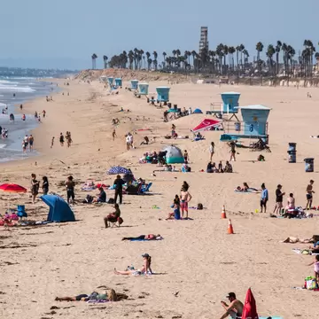 Huntington Beach, California - October 11, 2018: View up Huntington Beach with ocean, sand, bathers and lifeguard stands  License Type: media  Download Time: 2021-01-27T13:39:52.000Z  User:   Is Editorial: Yes  purchase_order:   