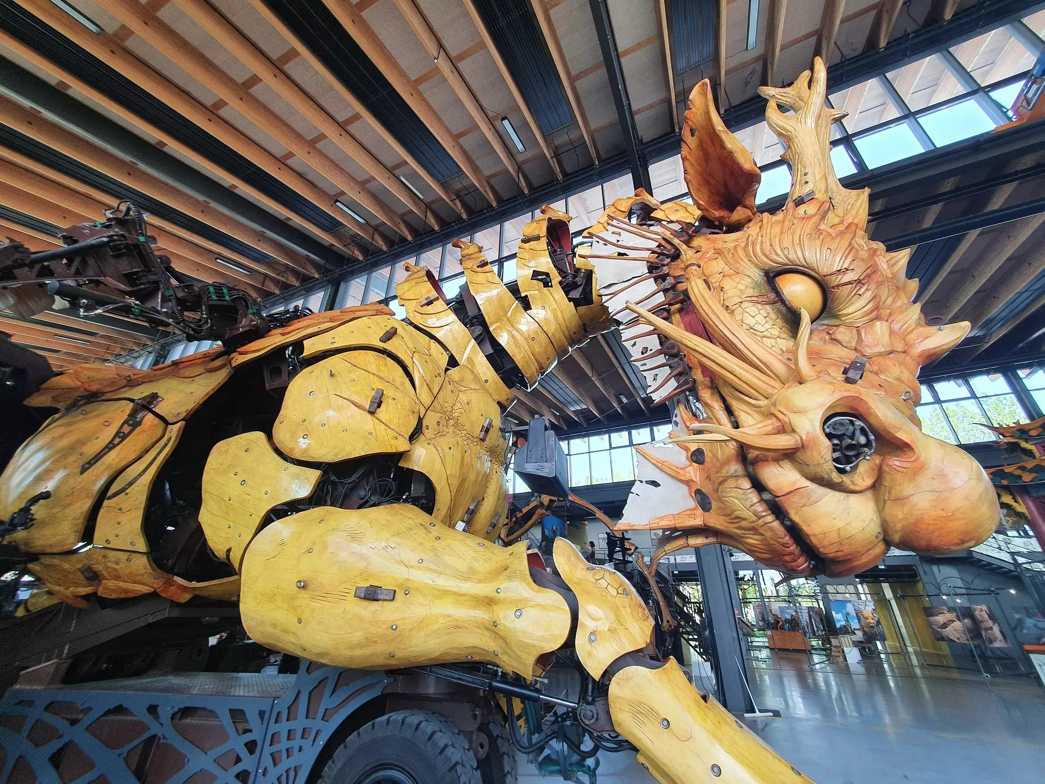 A machine in the form of a dragon is on display in an enclosed pavilion.