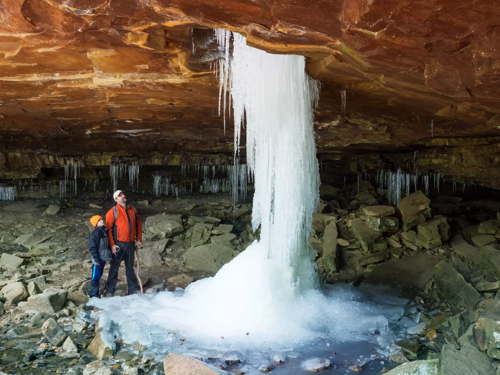 Father and son looking at the frozen waterfall at Glory Hole Falls, Arkansas, USA