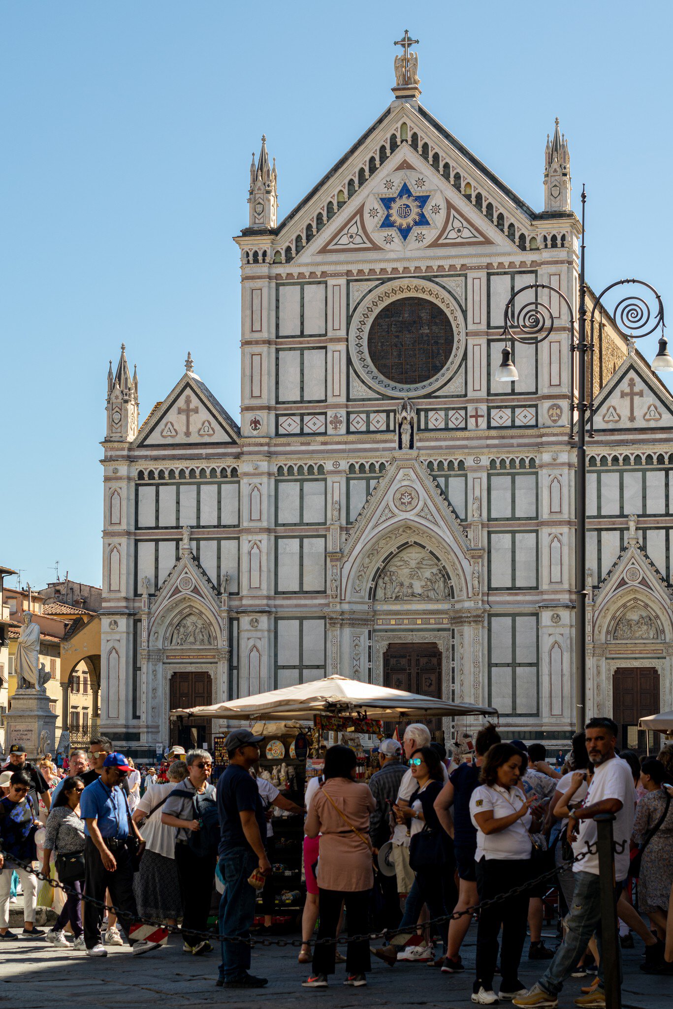 Tourists in Piazza di Santa Croce with the Basilica di Santa Croce in the background in Florence, Italy.
