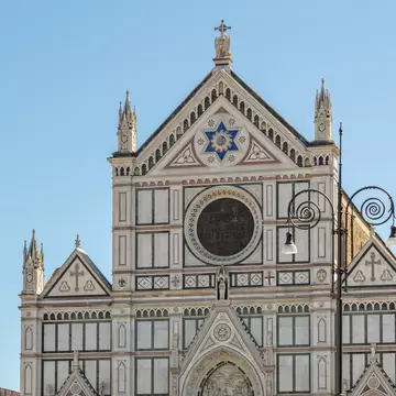 Tourists in Piazza di Santa Croce with the Basilica di Santa Croce in the background in Florence, Italy.
