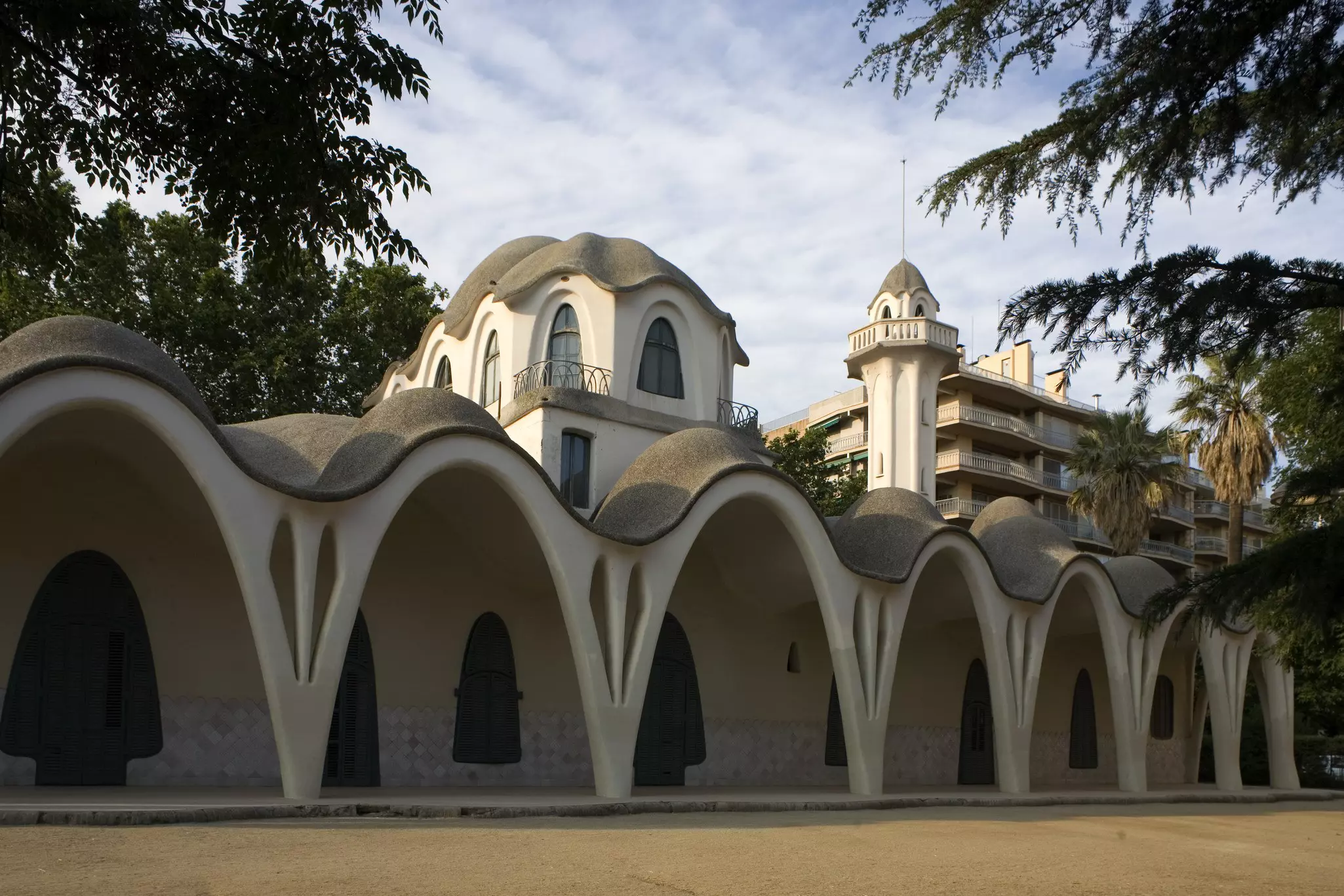a white building marked by arches in its design, built in the modernisme style in a town outside of Barcelona, Spain
