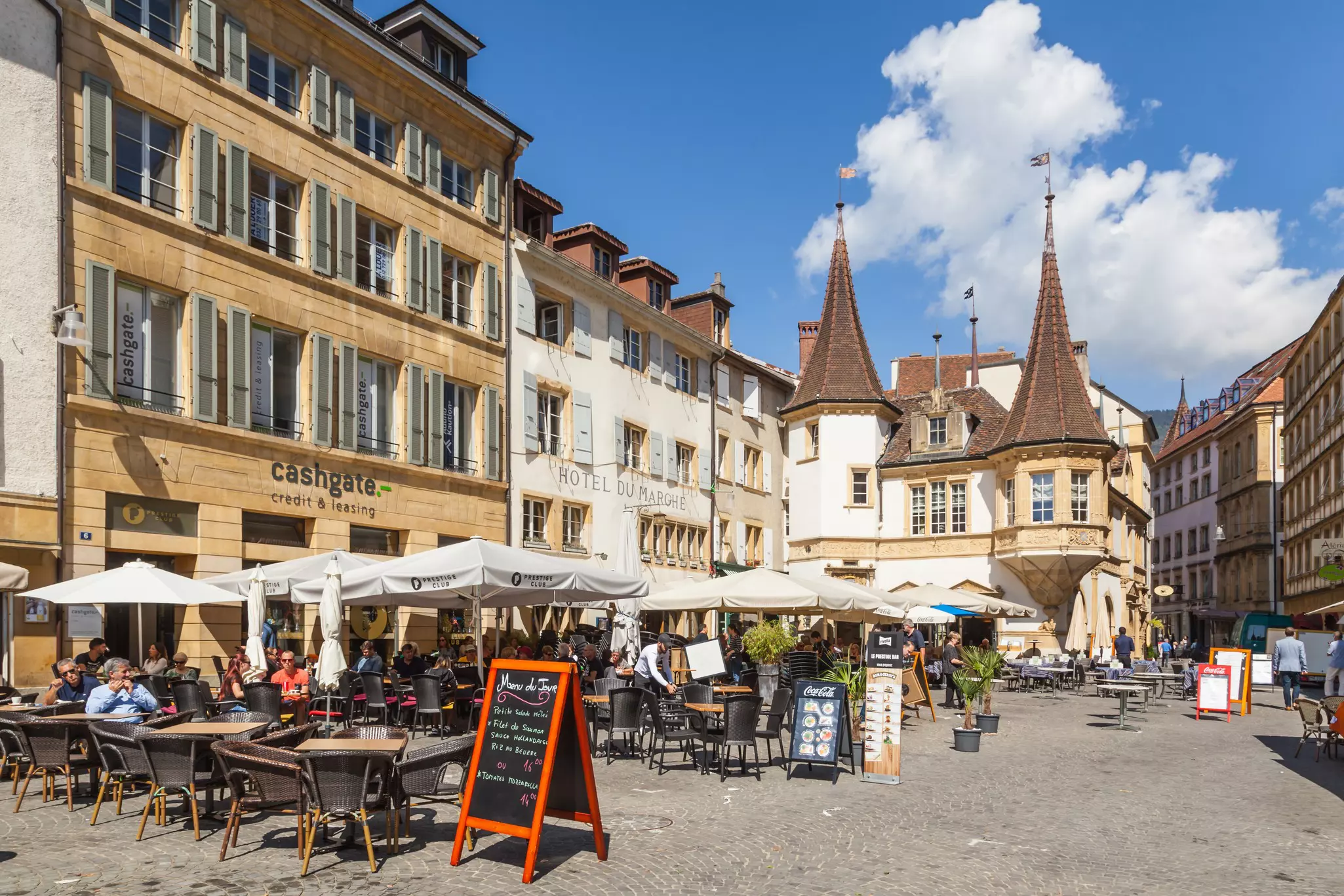 Neuchatel, Switzerland - Tourists enjoy outdoor dinning at Market place des Halles in front of La Maison des Halles building in Medieval ancient town of Neuchatel