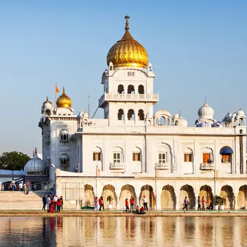 Exterior of the Gurdwara Bangla Sahib during the day.
569575438
amrit, amritsar, ancient, architecture, asia, asian, bangla, building, capital, cupola, day, delhi, dome, exterior, faith, gold, golden, gurdwara, guru, gurudwara, har, hinduism, historic, holy, icon, important, india, indian, krishan, landmark, marble, monument, most, new, nishan, old, people, place, pond, religion, sahib, sarovar, shrine, sikh, sikhism, temple, tourism, tourist, travel, worship