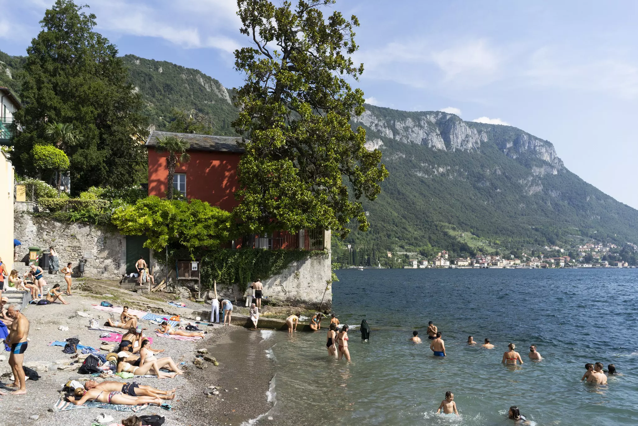 People enjoying the beach near Varenna on Lake Como, Italy.