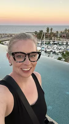 The room at Hotel El Ganzo with fluffy white linens on the bed with wood furniture. A bathtub is visible in the background.