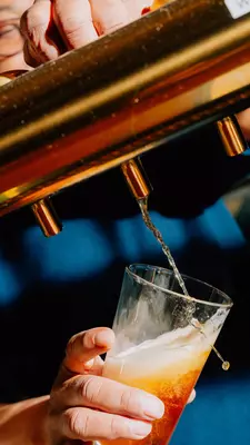 Three people playing the board game Scrabble in a bar