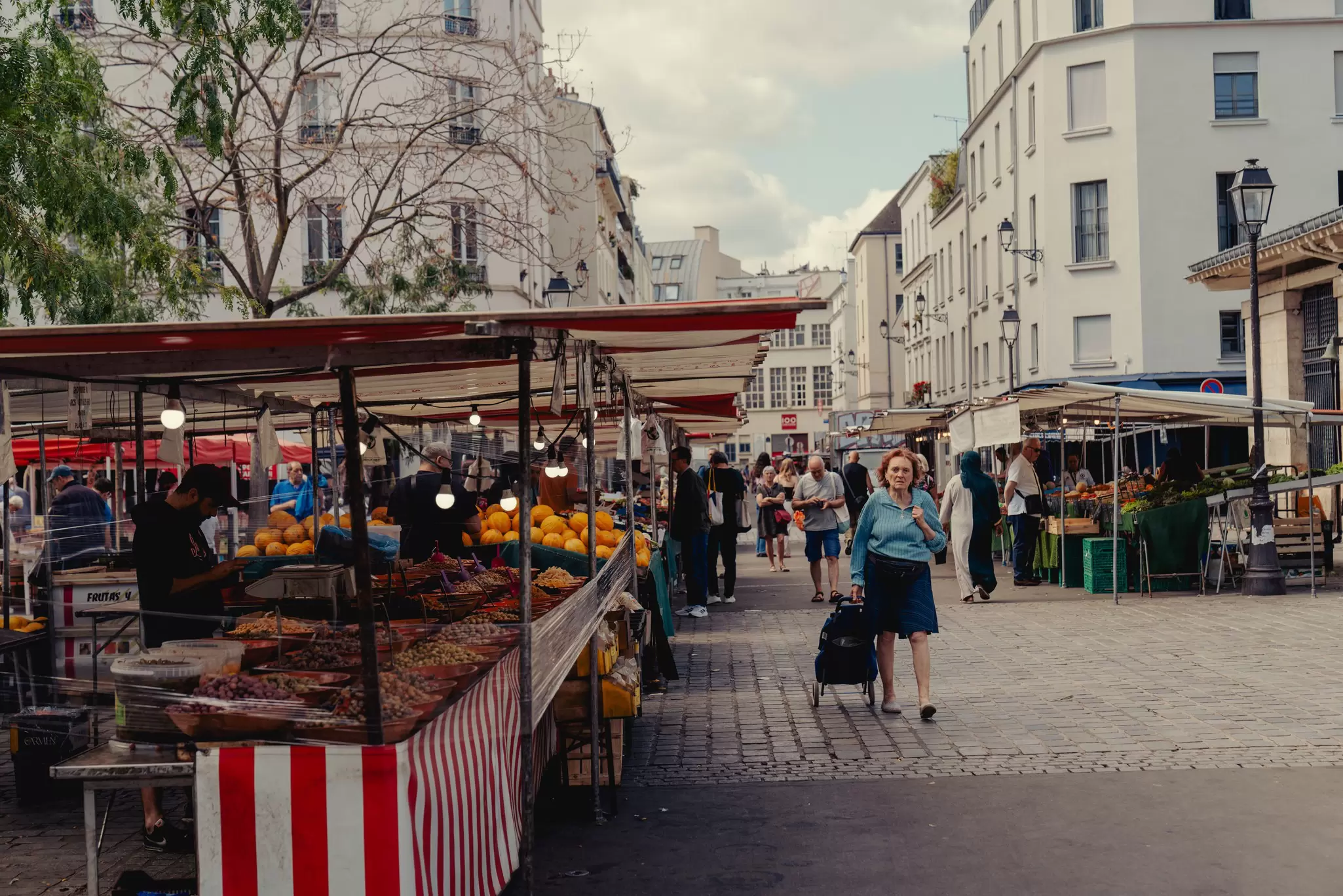 pedestrian walks around an outdoor market in Paris, France