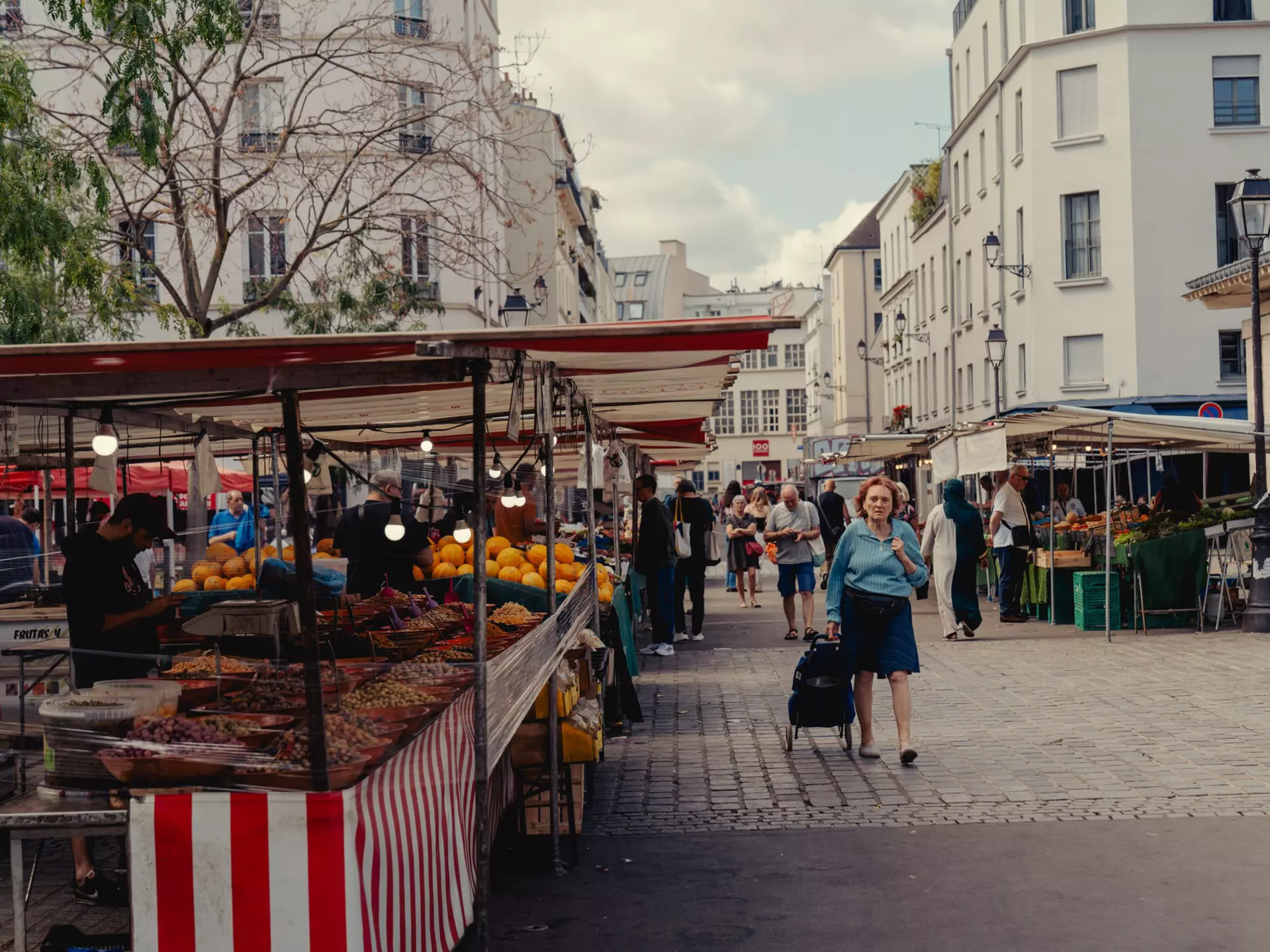 pedestrian walks around an outdoor market in Paris, France