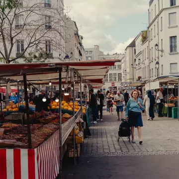 pedestrian walks around an outdoor market in Paris, France