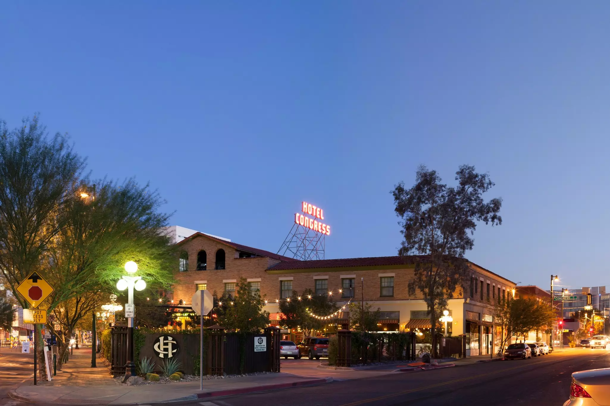 A low-rise building with a large illuminated sign on its roof that says "Hotel Congress".