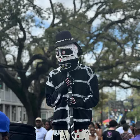 A person costumed in black and white at a parade.